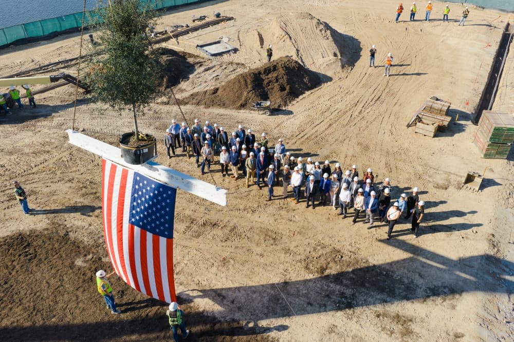 A group raises at flag at a construction site
