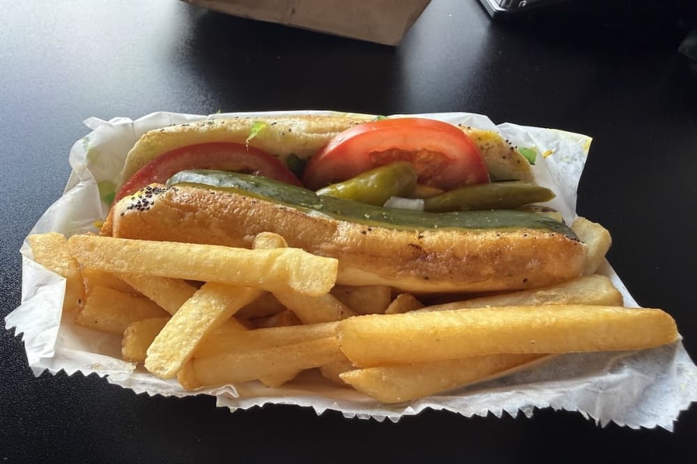 The Original Chicago Dog is served with fries and has mustard, relish, onions, tomato, sport pepper and a pickle spear on a poppy seed bun. (Andrew Creelman/Community Impact)