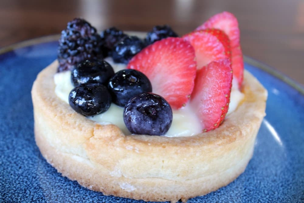 Baked crust filled with cream and topped with fresh fruit. 