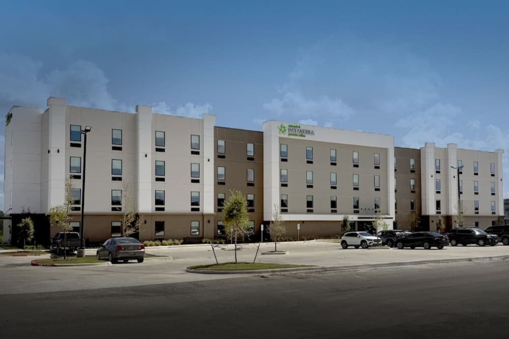the exterior of the light tan and brown brick hotel is shown.