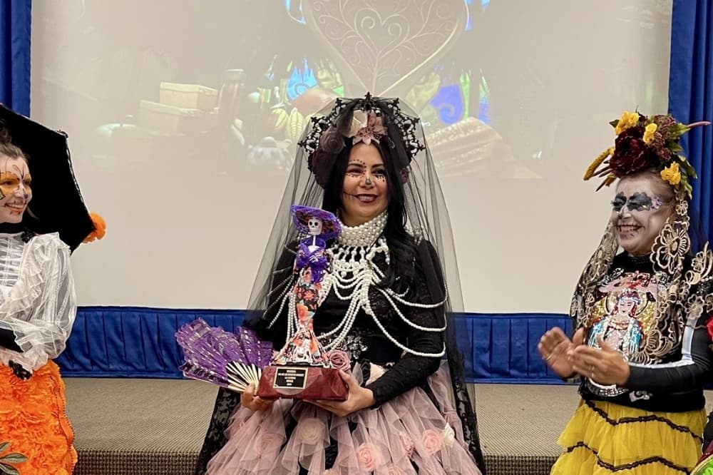 three women wearing day of the dead attire