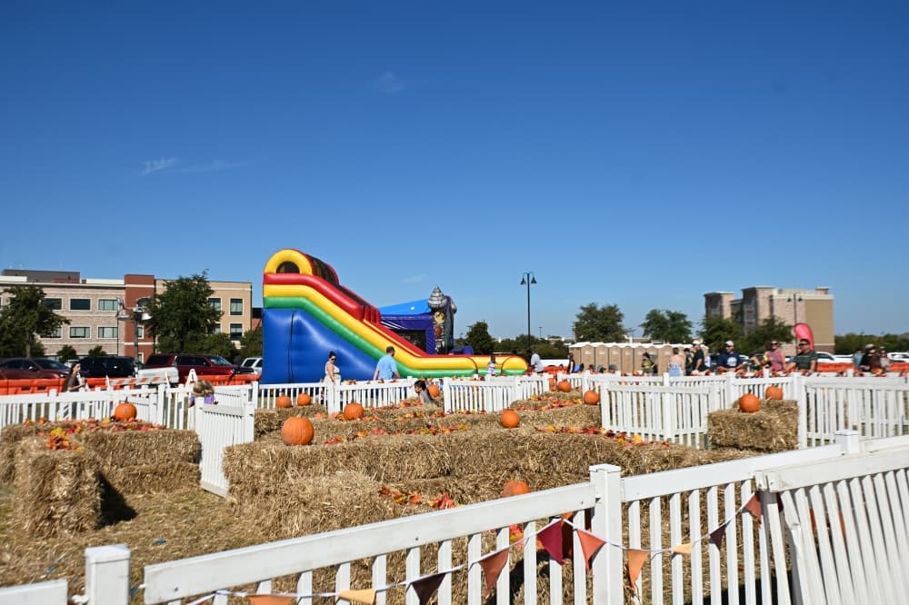 Children run through a hay maze