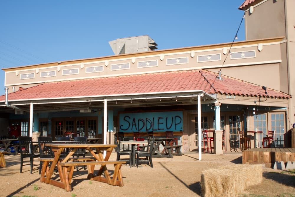 The restaurant's exterior with a painted sign that reads Saddle Up.