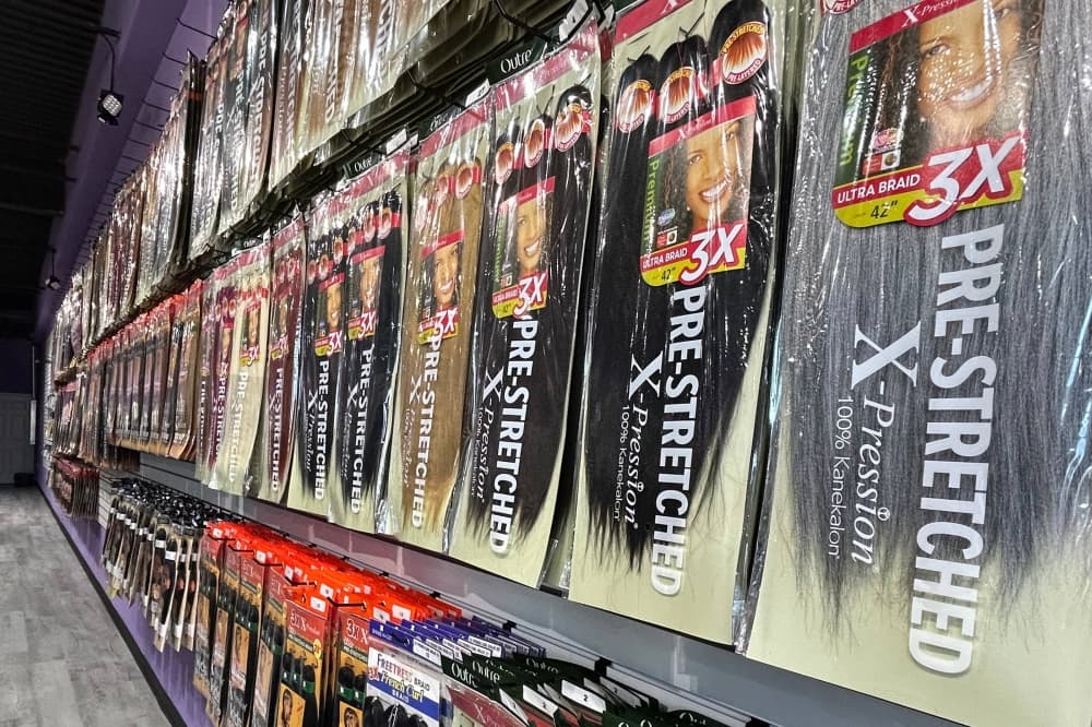 A variety of fake hair in separate bags displayed in a store. 