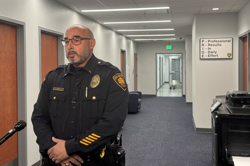 man in a police officer uniform stands in a hallway