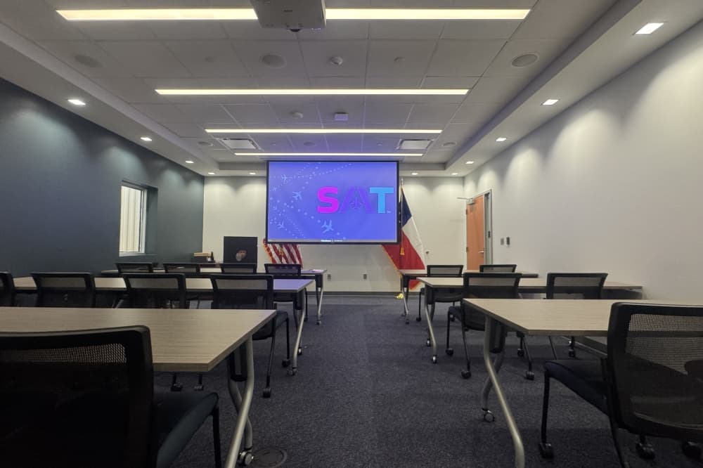 rows of tables and chairs leading up to a projector screen