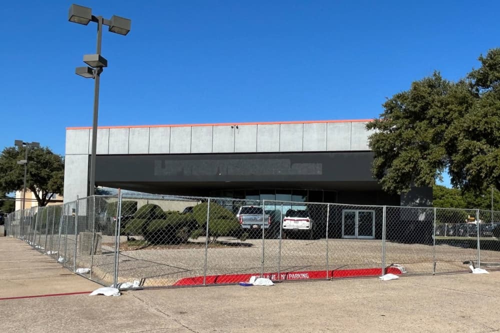 Exterior of a building surrounded by a chain link fence. 