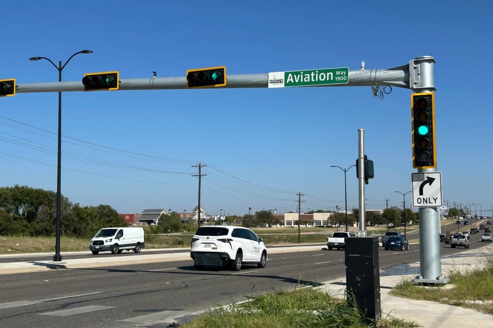 Aviation Way street sign on a signal light over a road. 