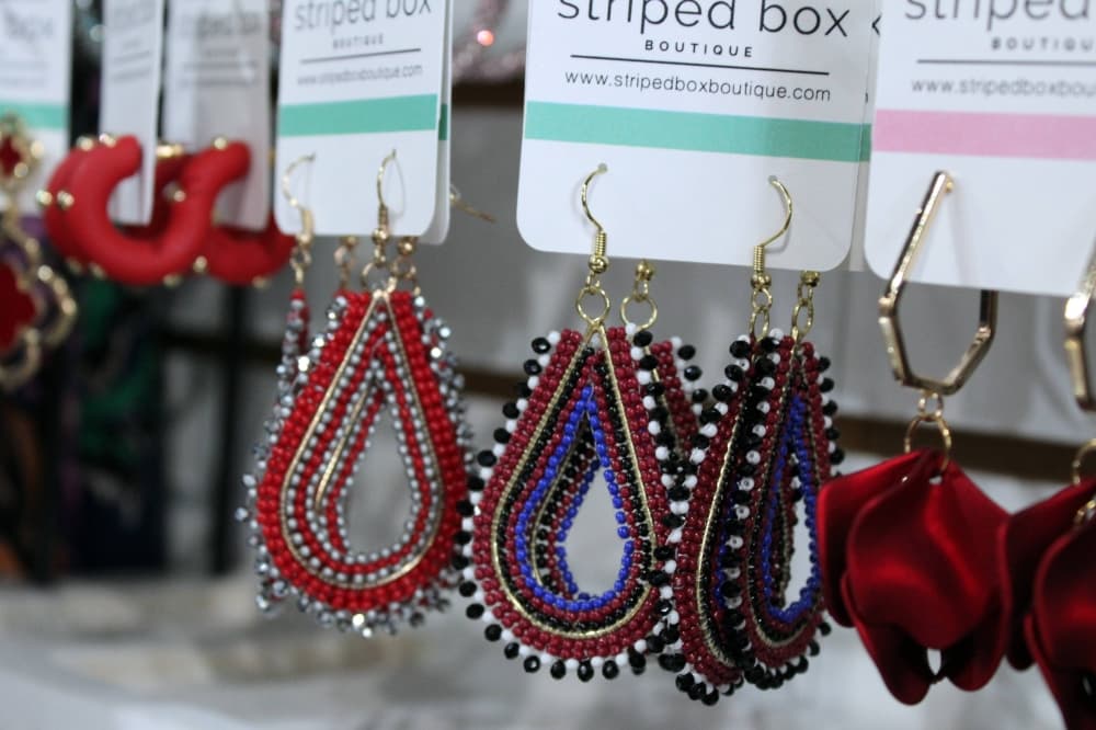 Earrings on display cards featuring Striped Box Boutique branding. 