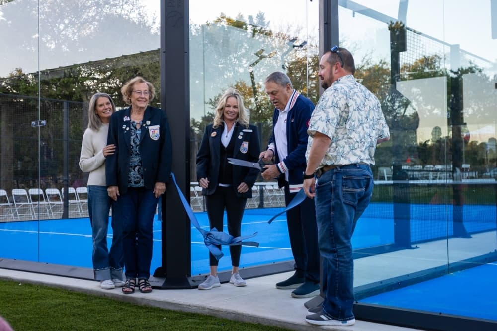 Australian tennis legend John Newcombe cuts the ribbon to his country club's newest padel ball courts.