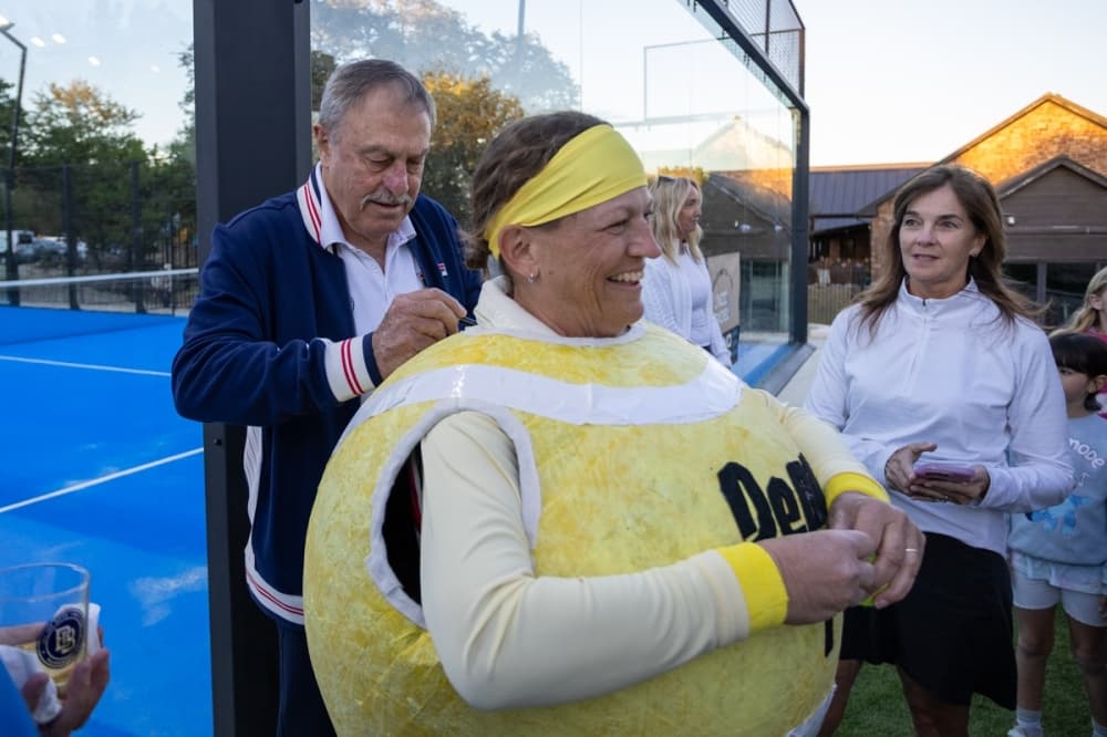 Australian tennis legend John Newcombe signs fan's costume.