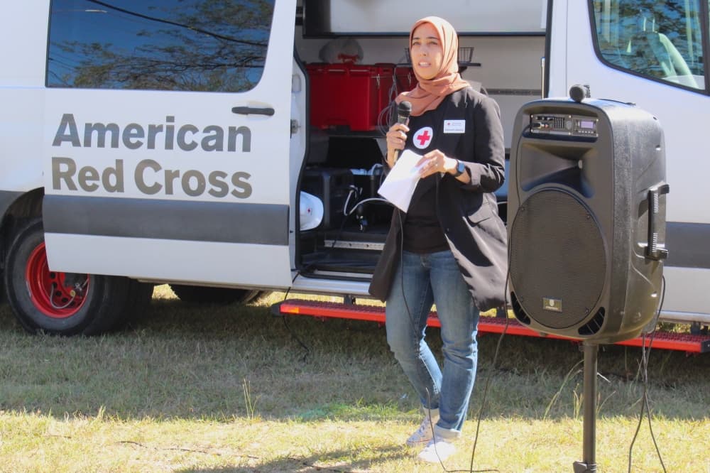 A woman speaks into a microphone at an event