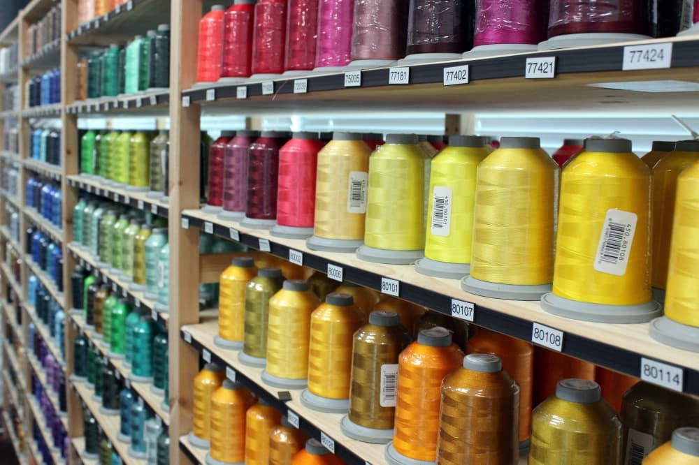 A variety of colors of thread displayed on store shelves.
