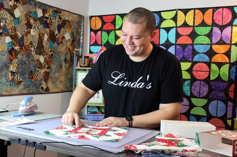 Male doing a podcast about quilting. 