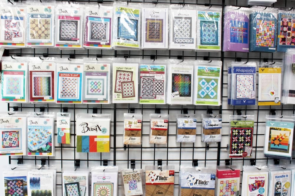 Quilt patterns displayed on a wall in a store. 