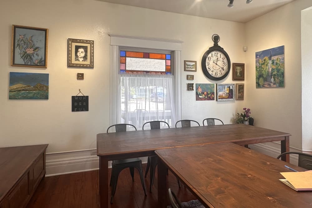 A room with paintings and a large wooden table
