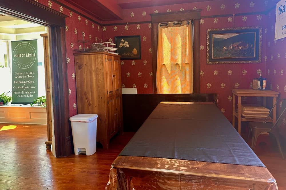The dining room with red wallpaper and a large table
