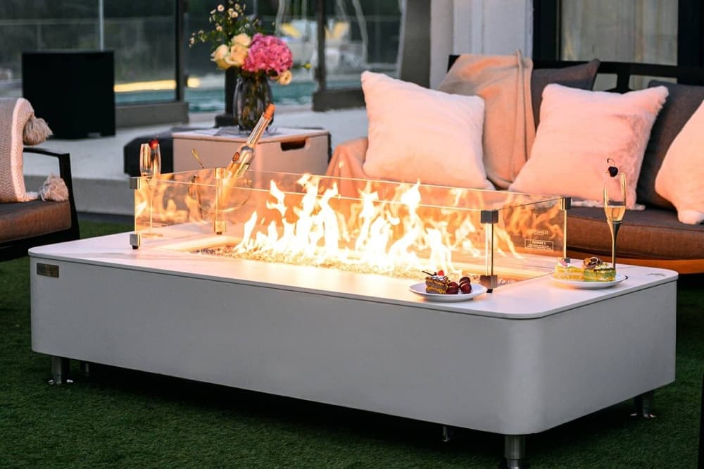 Rectangular fire pit surrounded by outdoor furniture. 