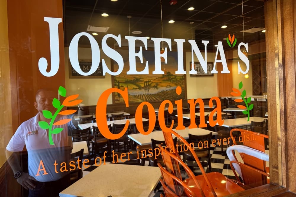 A male's reflection in a window featuring Josefina's Cocina signage. 