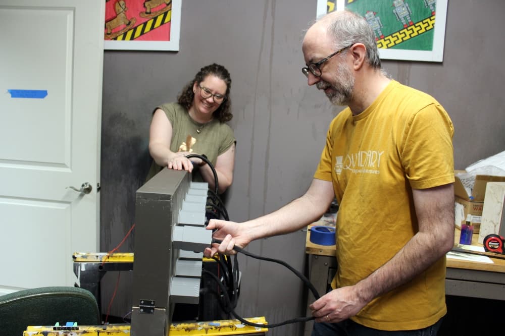 Male and female working on a wooden puzzle. 