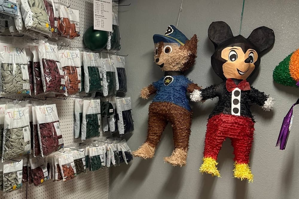 Pinatas and balloons displayed in a store. 