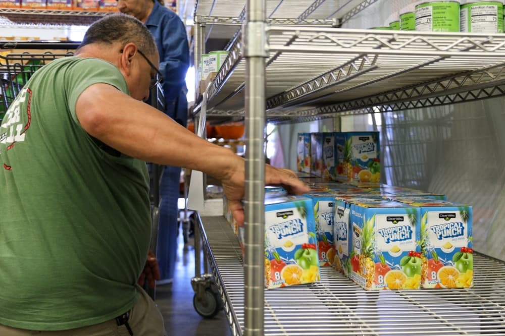 Volunteers stock shelves at The Kitchen Table for community members in need. (Ethan Thomas/Community Impact)