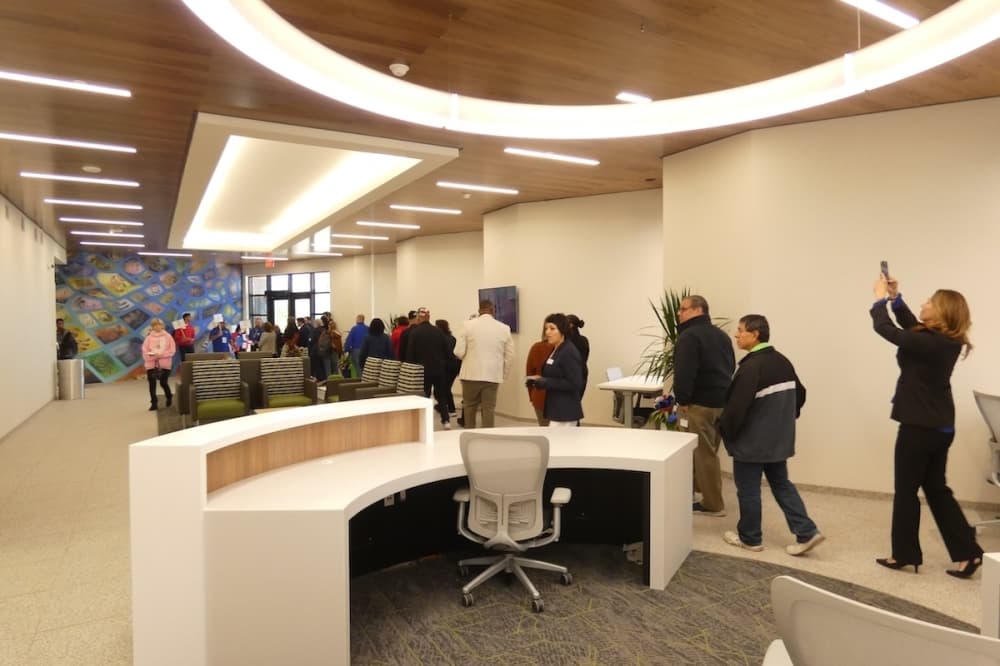 A group of people are seen walking in a single-file line around a new veteran support facility at Northeast Lakeview College in Live Oak, Texas.