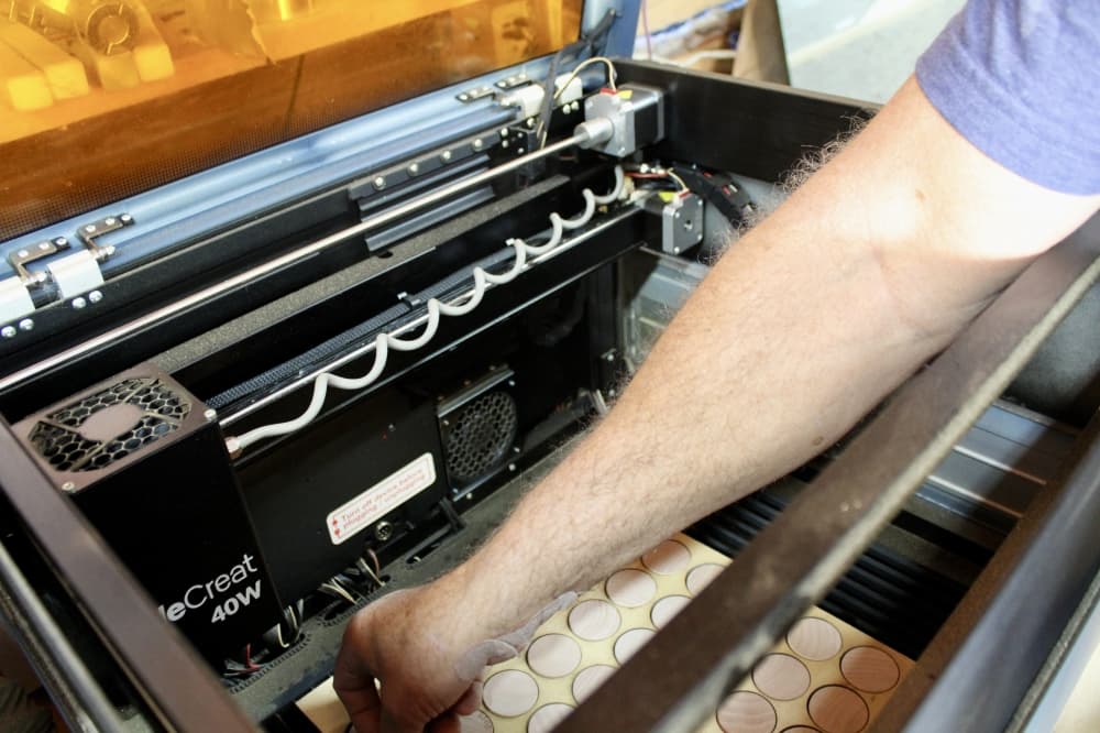 Utilizing a Computer Numerical Control machine, the Jamisons create tokens carved with biblical phrases. (Jovanna Aguilar/Community Impact)