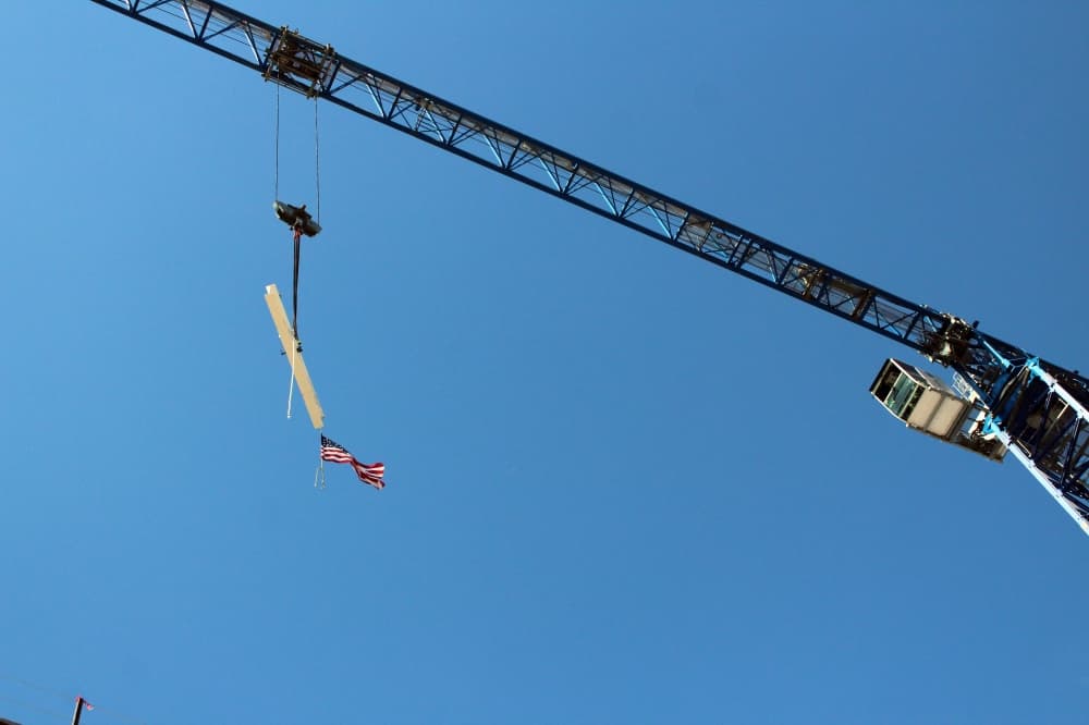 Construction beam being hoisted by a crane. 