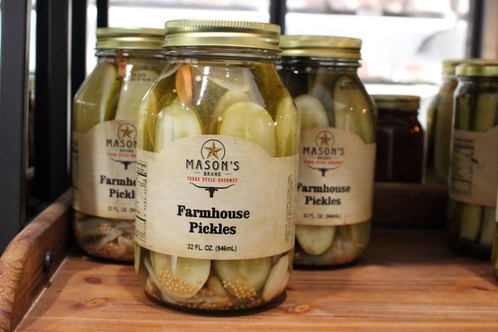 Canned pickles displayed on a store shelf. 