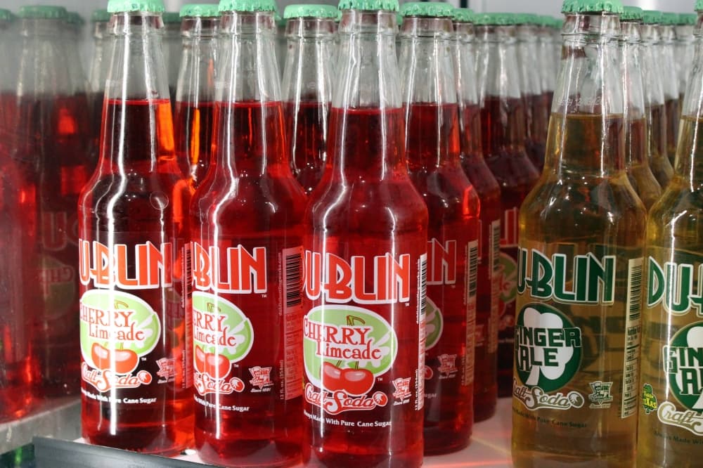 Bottles of red soda in glass jars featuring Dublin branding. 
