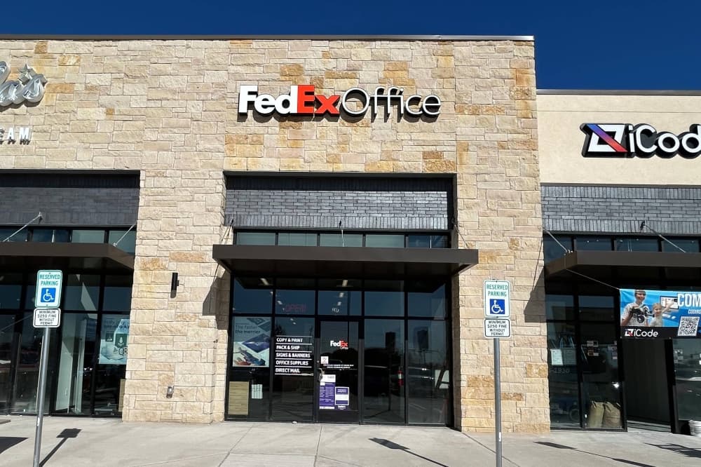 Exterior of a strip mall featuring FedEx Office over one spot. 