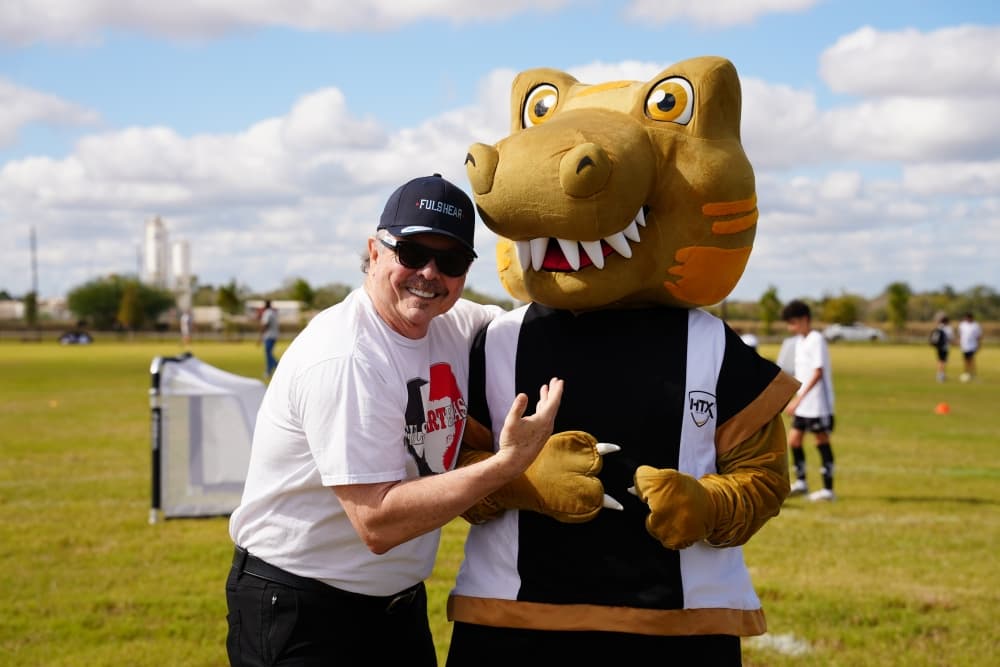 person poses with a mascot