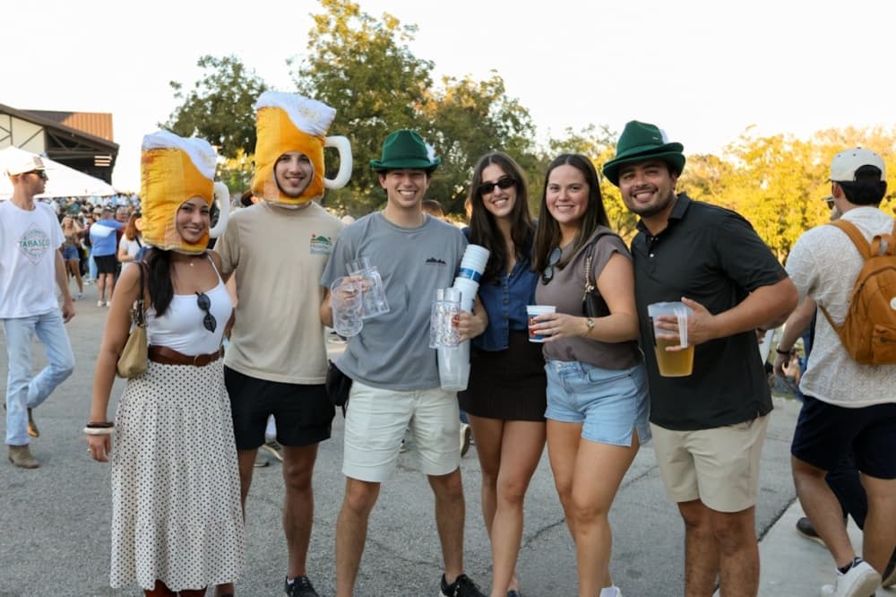 Attendees dress in traditional fedoras and beer mug-shaped hats to celebrate German heritage at Wurstfest 2025. (Ethan Thomas/Community Impact)