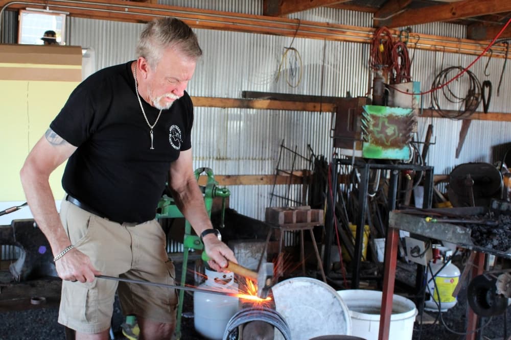 Male using blacksmith tools in a blacksmith shop. 
