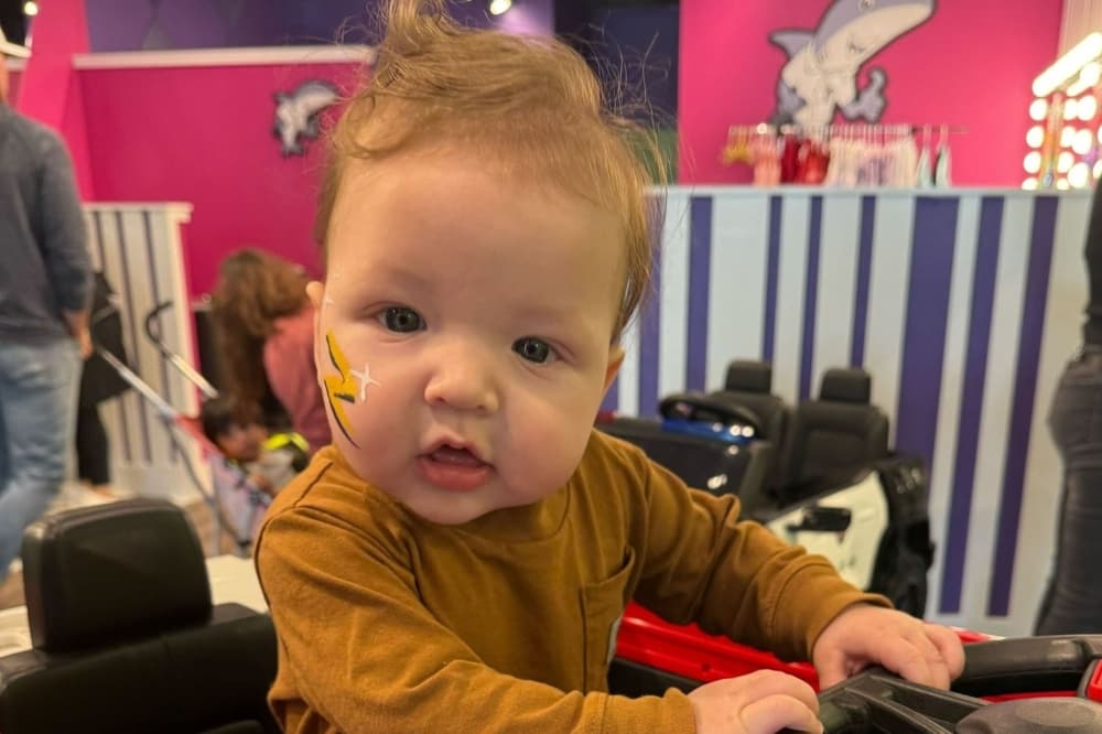a baby in a haircut seat