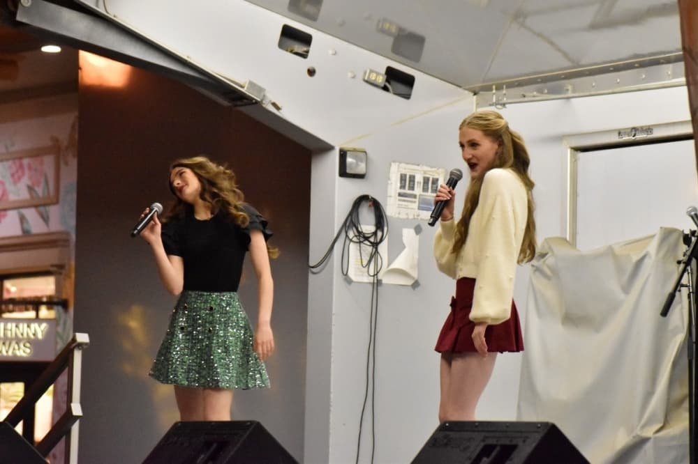 two girls singing Christmas carols 