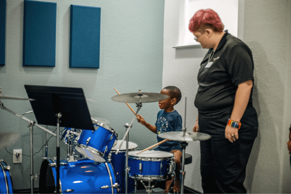 Group of children participating in a guitar and voice workshop at Magnolia’s Leading Note Studios, exploring instruments, teamwork, and creative expression in a supportive environment.