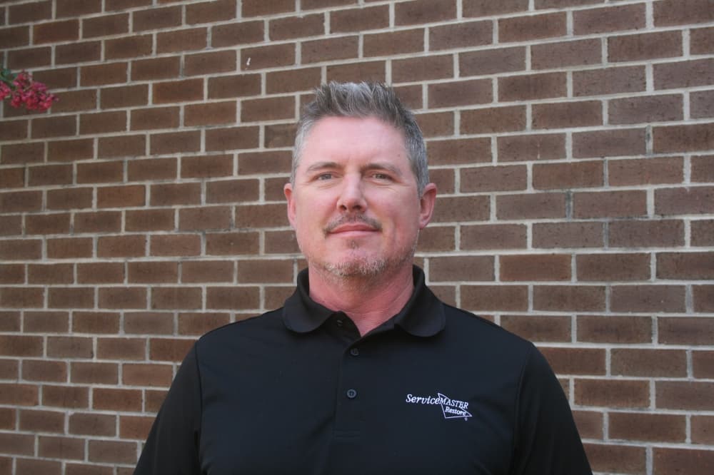 man standing against brick background