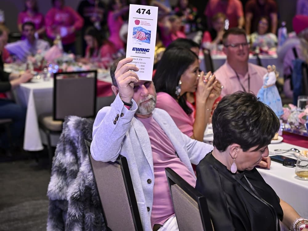 A bidder participates in the SKI Plano auction, helping drive funds for student and teacher initiatives across Plano ISD.