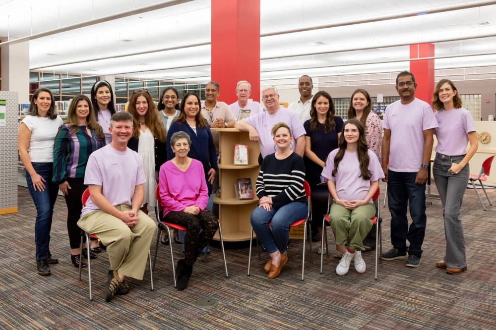 Group of male and female adults posting for a photo. 