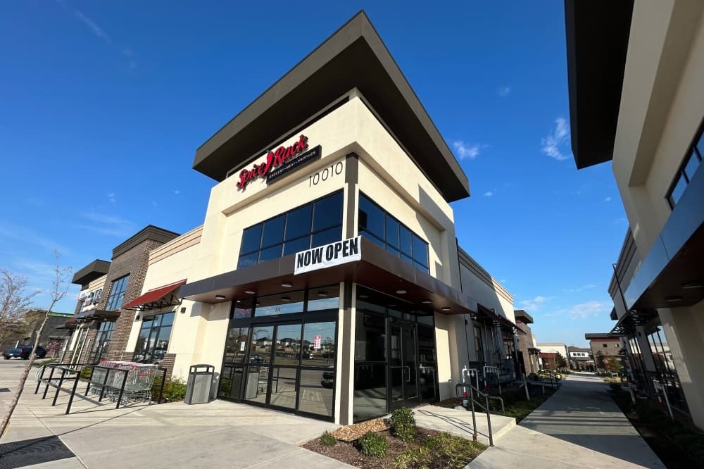 Exterior of a corner spot in a shopping center featuring Spice Rack signage. 