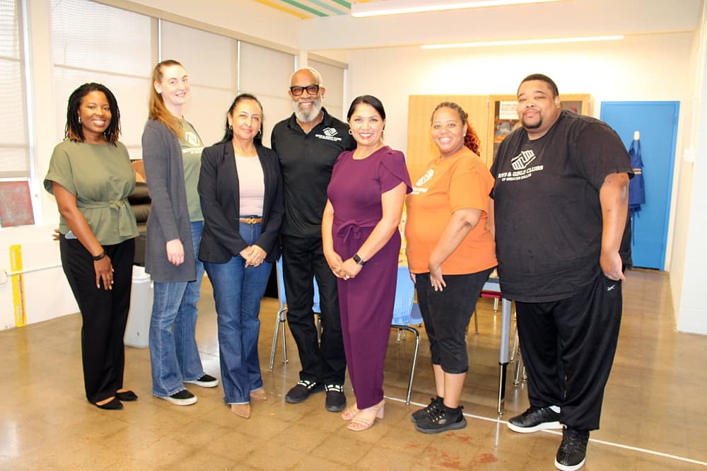 Five women and two men stand side by side while posing for a picture. 