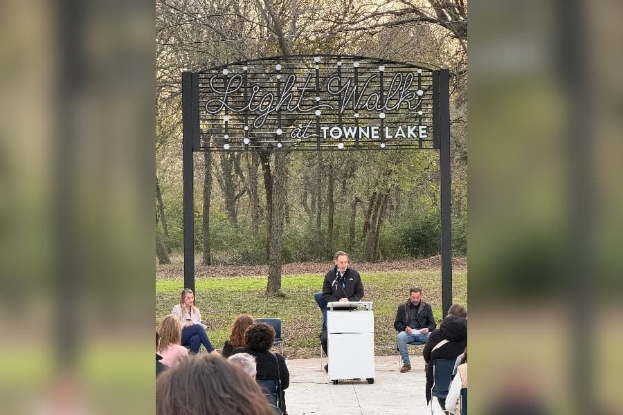 City Manager Paul Grimes (center) speaks during a ribbon cutting event for the Light Walk at Towne Lake trail on Dec. 3.