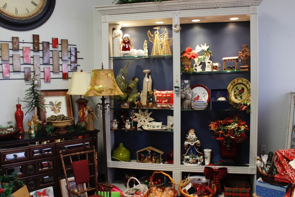 A glass case with plates, decorations and other trinkets. 