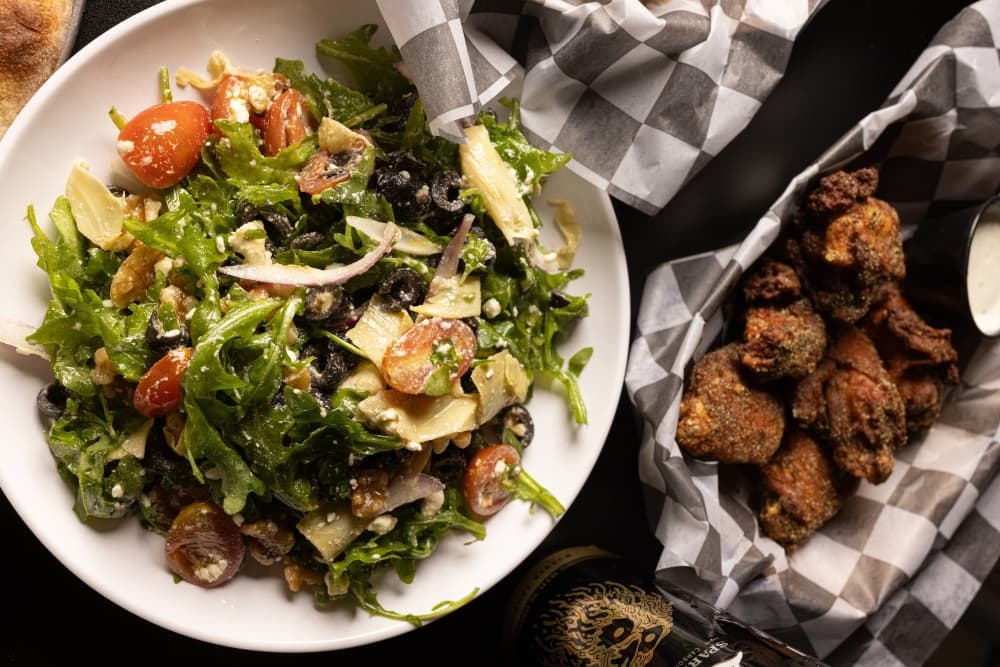 An image of the salad and some wings. 