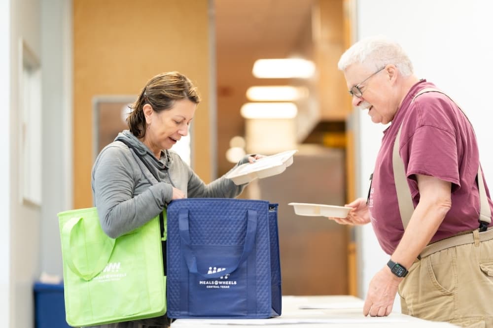 man talks to woman with a blue bag