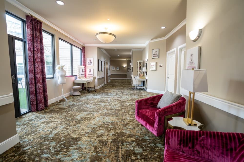 A carpeted hallway with loveseats and decorations