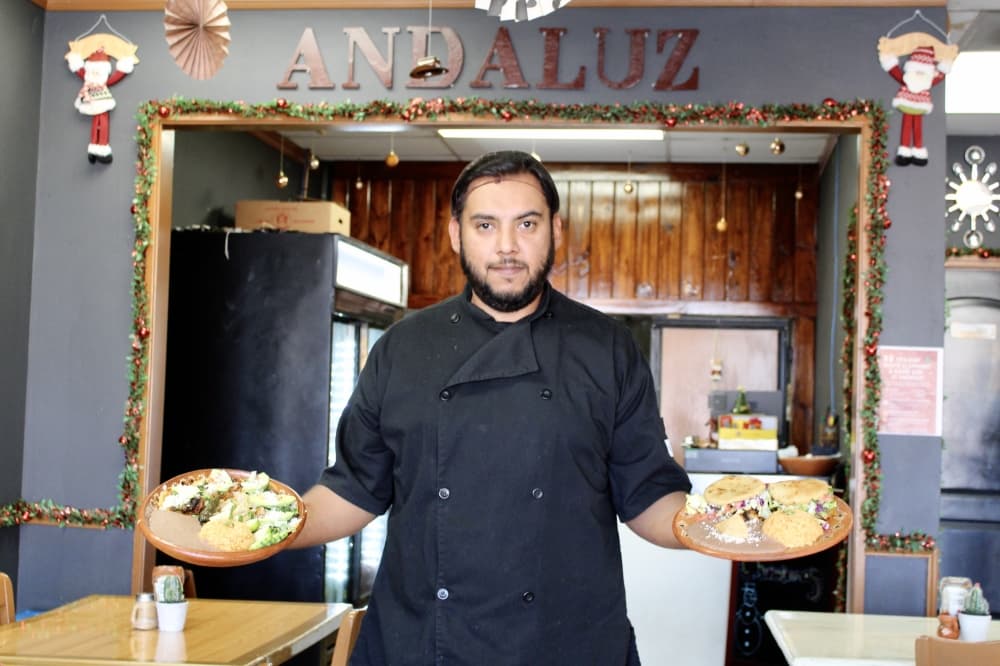 man holding out plates of food