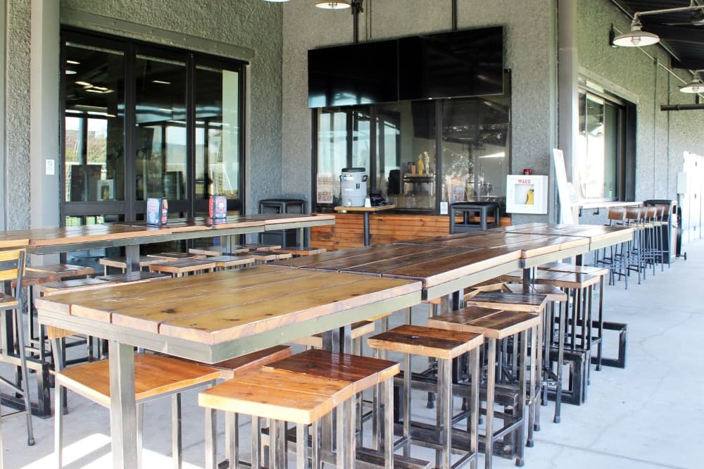 Covered patio featuring high tables and chairs. 